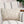 Load image into Gallery viewer, Floral-patterned pillow on a striped sofa with a plant and books in the background
